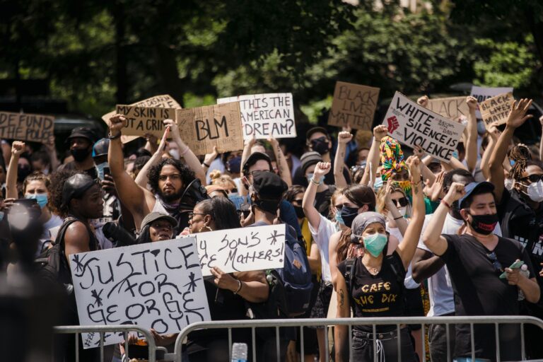Protesters rally for justice and equality, displaying powerful signs in a city street.
