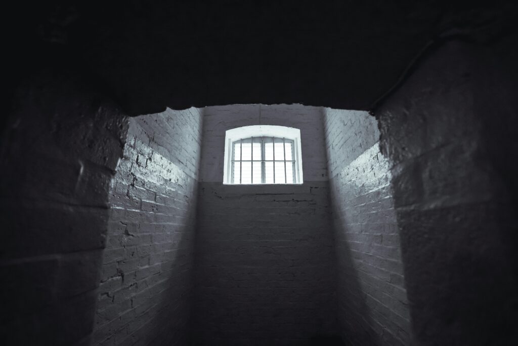 Moody shot of an abandoned prison cell in Hong Kong with dim lighting and shadowy walls.