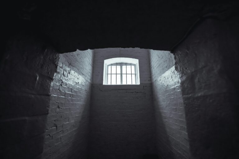Moody shot of an abandoned prison cell in Hong Kong with dim lighting and shadowy walls.