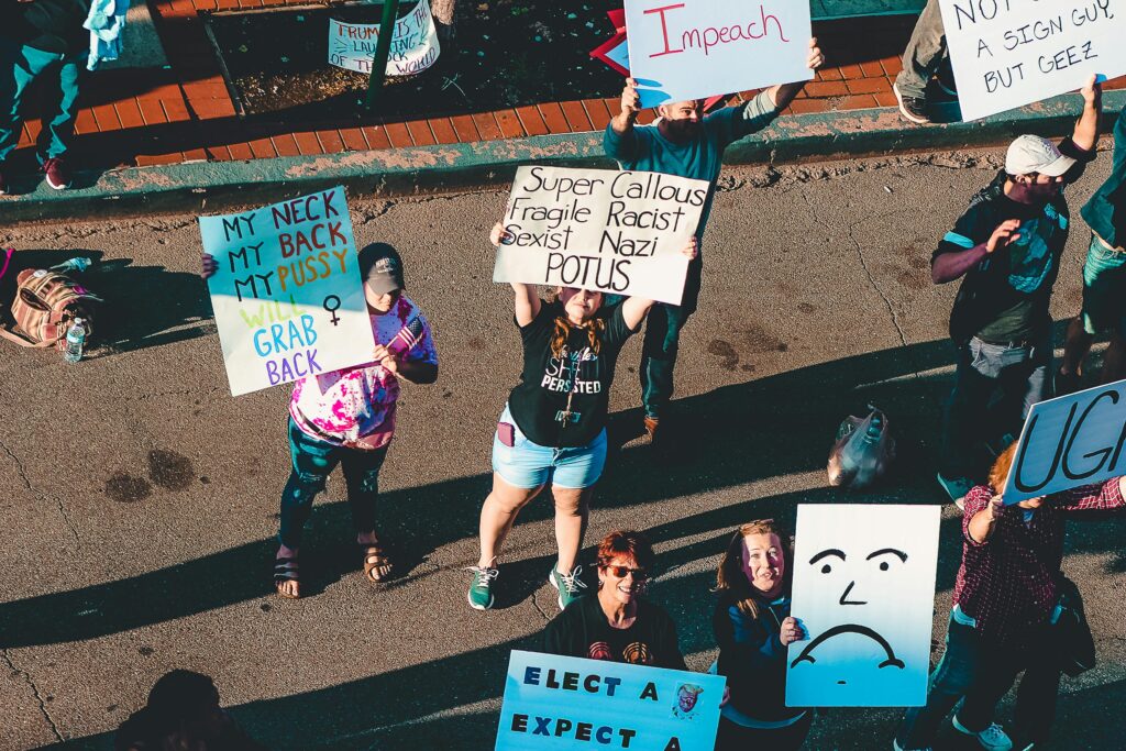A diverse group of protesters holding signs advocating for political change in Wheeling, WV.