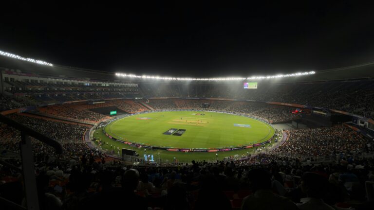 A captivating night cricket match with a large crowd at Narendra Modi Stadium in Ahmedabad, India.