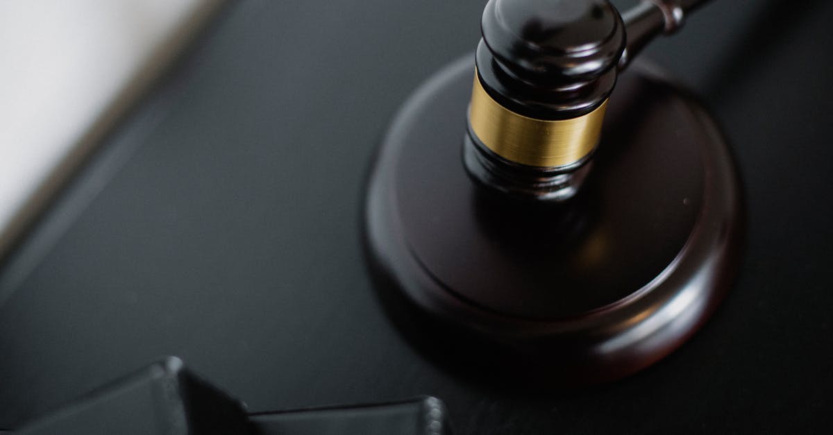 From above of wooden gavel on round surface near folders on table in courtroom