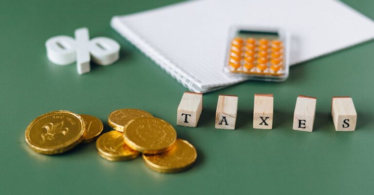 Close-up of tax-related items including coins, calculator, and word 'taxes' on a green background.