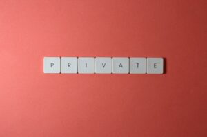 White letter tiles spelling 'PRIVATE' on a red background, offering conceptual minimalist design.