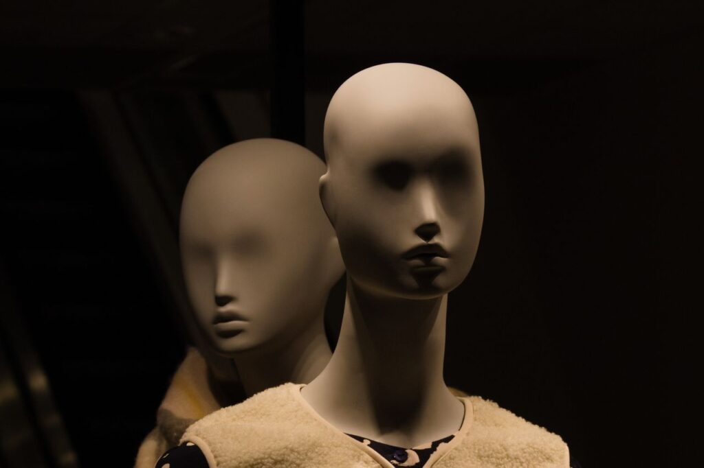 Close-up of two mannequins in dim lighting, creating a mysterious and eerie ambiance.